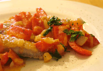 Golmakrele auf Teller mit Tomate und Paprika